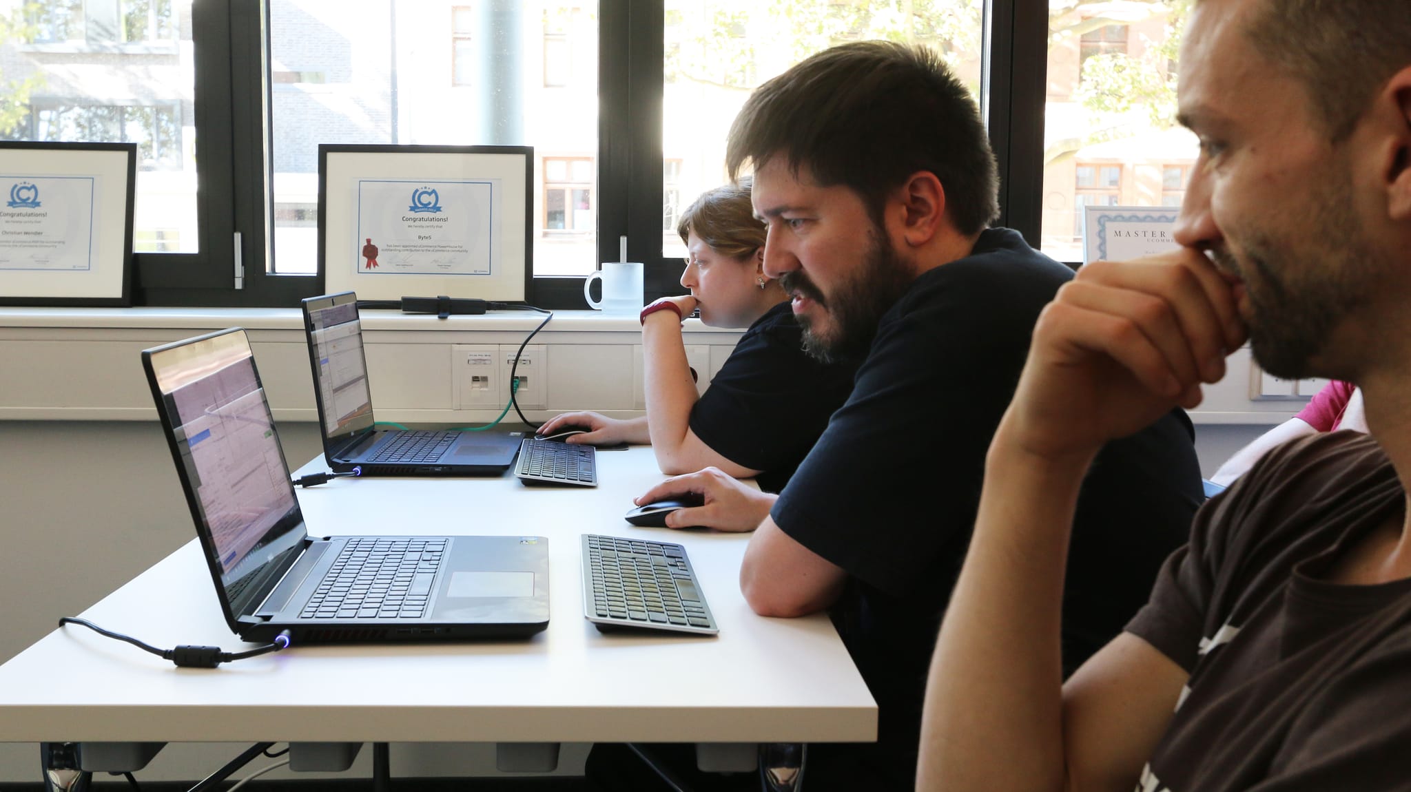Drei Personen arbeiten an ihren Laptops