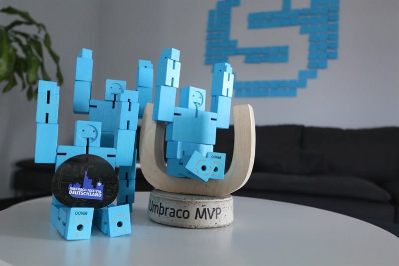 Figuren die auf dem Umbraco MVP Preis sitzen und stehen